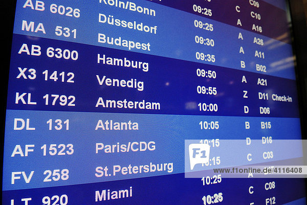 Monitor mit Liste von Flügen und Städtenamen im Abflugterminal eines Flughafens