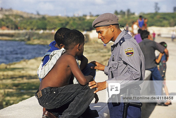 Polizist im Gespräch mit Kindern am Malecon  Havanna  Kuba