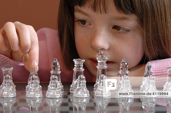 Young girl contemplating a chess move