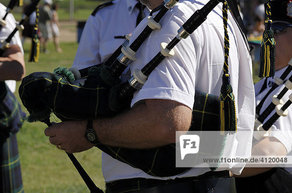 Bagpiper with bagpipes at a Highland Games gathering