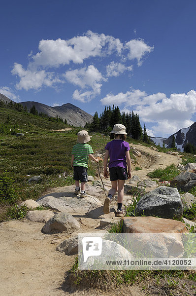 Brother and sister walking along a mountain hiking trail
