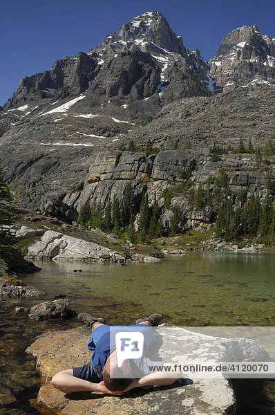 Wanderer ruht sich aus auf einem Felsen  Lake O'Hara  Yoho Nationalpark  British Columbia  Kanada