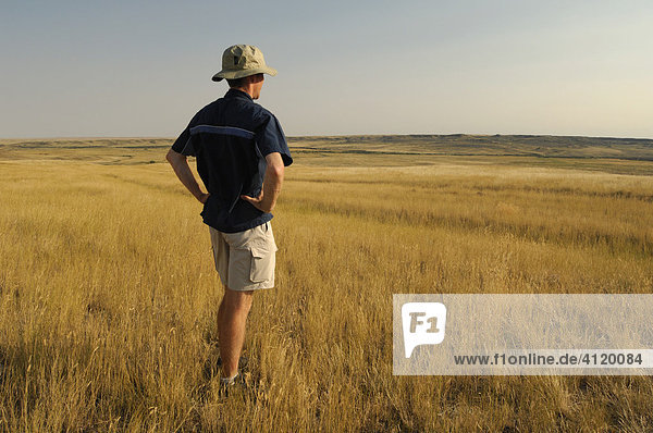 Hiker taking time to enjoy the view at Grasslands National Park  Saskatchewan  Canada