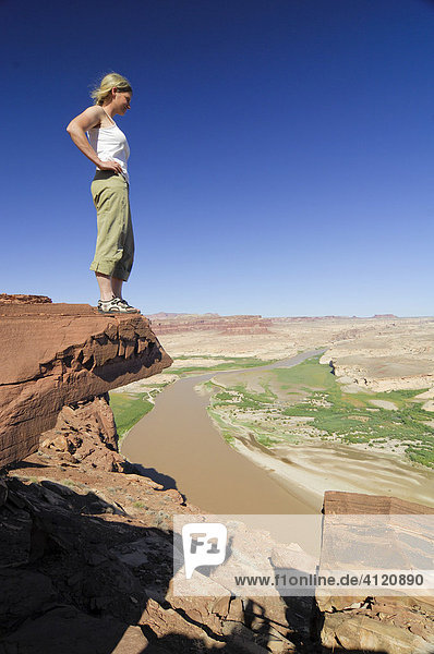 Eine Frau steht auf einer Felsvorsprung über der Glen Canyon National Recreation Area  Colorado Plateau  Utah  USA