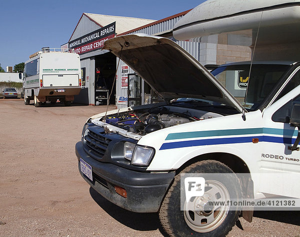 Four-wheel drive vehicle (4WD or AWD) with open bonnet or popped hood in front of garage repair shop  Western Australia  Australia