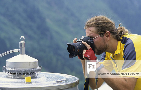 Fotograf fotografiert eine Milch-Kühlmaschine auf einer Alm  Tirol  Österreich  Europa