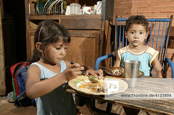 Guarani children eating in the poor area of Chacarita  Asuncion  Paraguay  South America