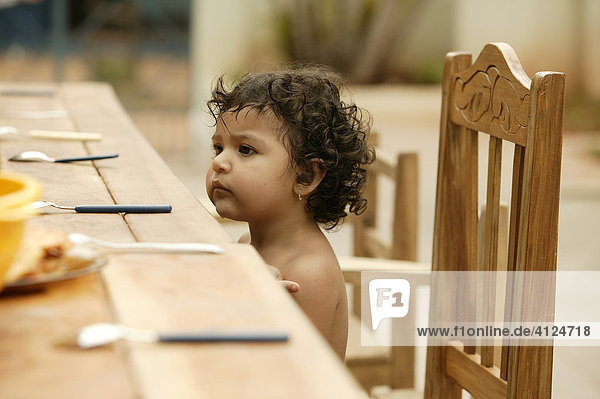 Little child sitting at the table waiting for food  Asuncion  Paraguay  South America