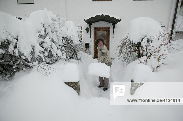 Woman shovelling snow  Upper Bavaria  Bavaria  Germany  Europe