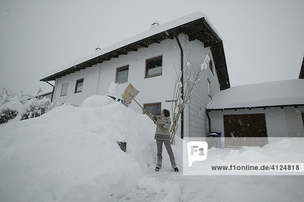 Frau beim Schnee schaufeln  Oberbayern  Bayern  Deutschland  Europa