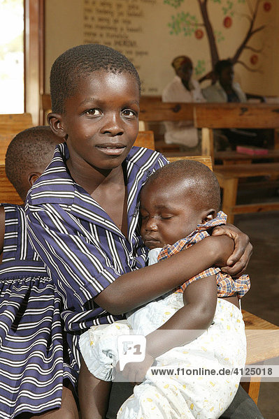 Boy holding sleeping child  Sehitwa  Botswana  Africa