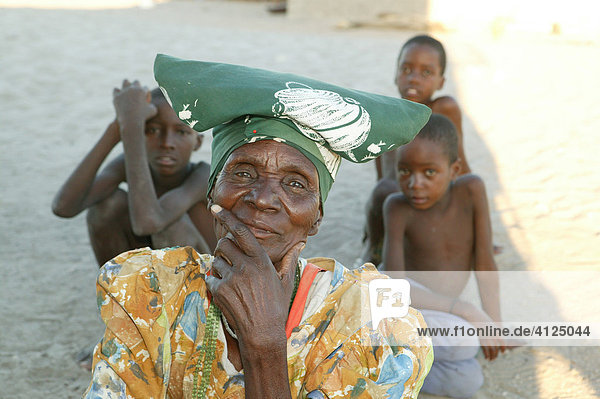 Großmutter sitzt mit Enkelkindern im Schatten  Sehitwa  Botswana  Afrika