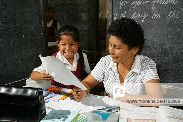 Schoolgirl and her teacher during class  Arawak natives  Santa Mission  Guyana  South America