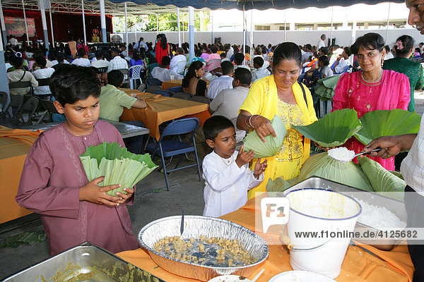 Visitors at a Hindu Festival eating rice from leaves  Georgetown  Guyana  South America