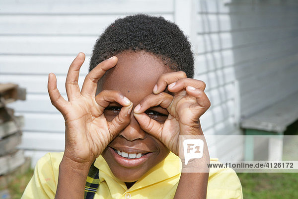 Girl forming glasses around her eyes with her fingers at an Ursuline convent and orphanage  Georgetown  Guyana  South America