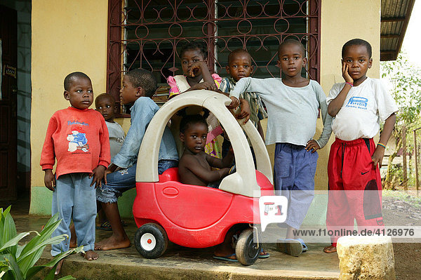 Children playing with a peddle car at an AIDS / HIV orphanage in Douala  Cameroon  Africa