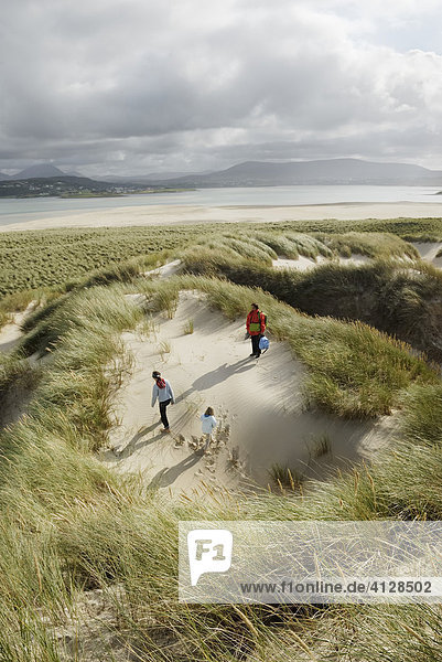 Family is hiking in dunes at the northern coast of Co Donegal  Ireland