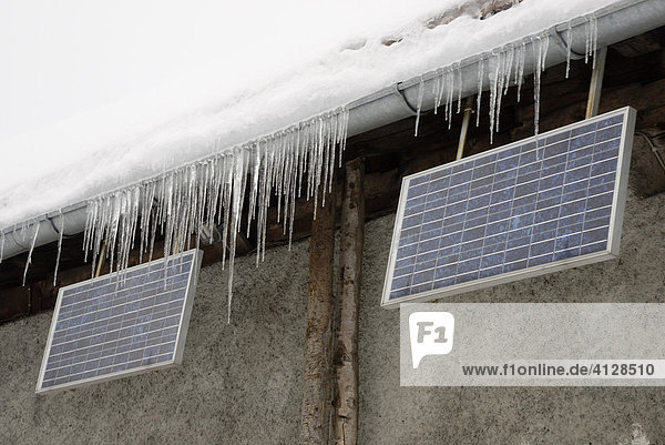 Eiszapfen mit Solarpanelen an einer Almhütte Bayerische Alpen  Wagner Alm Deutschland