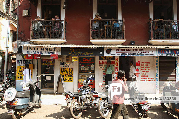 Tourist auf dem Balkon eines Restaurants in einem alten portugiesischen Gebäude schauen auf die Straße  Panaji  Panjim. Goa  Indien