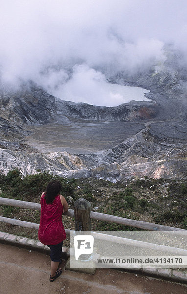 A woman looks into the main crater of the volcano Poas  Costa Rica  Central America