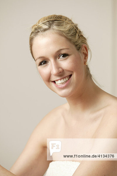 Young blonde woman wrapped in white towel  smiling