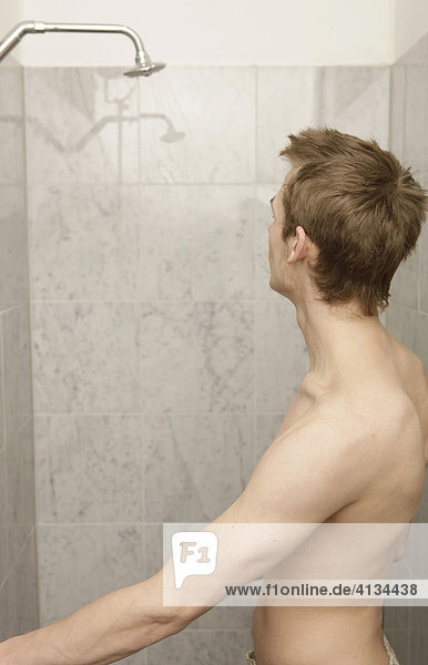 Junger Mann in der Dusche