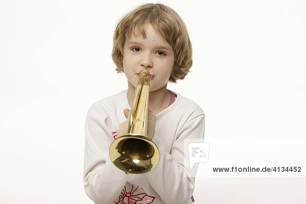 Dunkelblondes 8-jähriges Mädchen spielt Kindertrompete