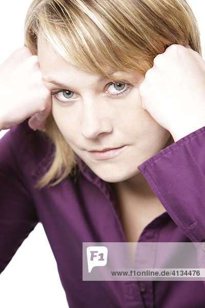 Blonde woman wearing a purple shirt  her head leaning on her hands