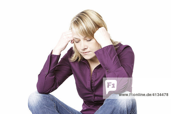 Blonde Frau im lila Hemd  stützt den Kopf mit den Händen  Augen geschlossen