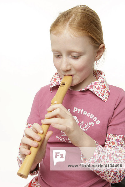 8-jähriges Mädchen mit roten Haaren spielt Flöte  Blockflöte