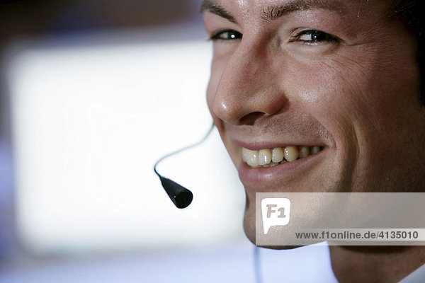 DEU  Bundesrepublik Deutschland : Mann telefoniert mit Headset  Kopfhörer  Hörsprechgarnitur vor Computerbildschirm