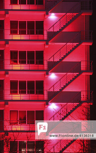 NLD  Niederlande  Rotterdam: Gebaeude in der Innenstadt  rot beleuchtet. Feuertreppen.
