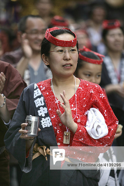 Japan  Tokio: Kanda-Sai. Hohes Fest der Shintoistischen Gemeinde des Kanda-Moyjin-Schrein. Die Gottheit des jeweiligen Tempels wird bei diesen Matsuri-Schreinfesten in heiligen Sänften durch die Gemeinde getragen  traditionelles japanisches  religiöses Fest. Frau trinkt Bier aus einer Dose.