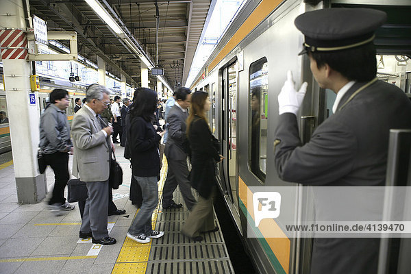 Schaffner  Nahverkehrzug am JR-Line Bahnsteig  Tokyo Station  Tokio  Japan  Asien