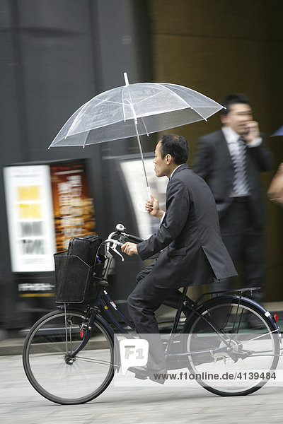 Radfahrer mit Regenschirm  Tokio  Japan  Asien