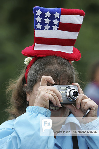 Woman taking pictures during Fourth of July celebrations (Independence Day) in Gustavus: population 400  Alaska  USA  North America