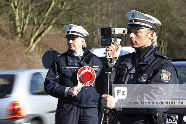 Speed limit enforcement  police measuring speed with a laser measuring device  Mettmann  North Rhine-Westphalia  Germany  Europe