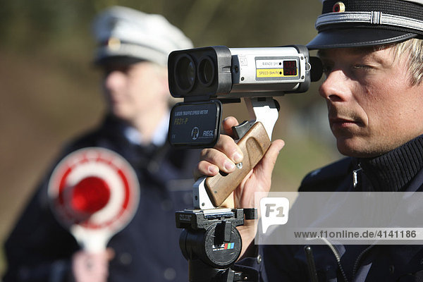 Speed limit enforcement  police measuring speed with a laser measuring device  Mettmann  North Rhine-Westphalia  Germany  Europe