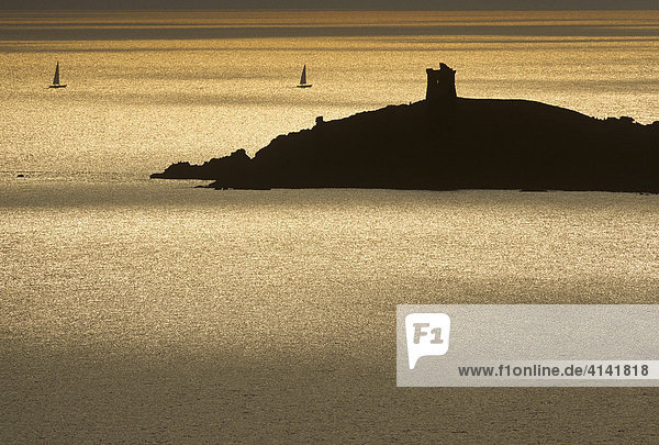 Genuesen -Turm auf der Punta d'Omigna bei Cargese im Gegenlicht am Abend mit Segelbooten  Westküste von Korsika  Frankreich