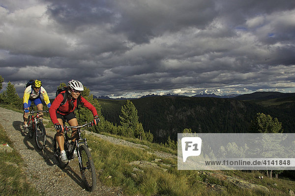 Mountainbiker und -bikerin an der Gedrum Alm mit Blick auf die Dolomiten  Sarntal  Südtirol  Italien