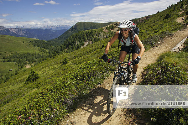 Female mountain biker at Mt. Kreuzjoechl  view of the Dolomites  Italy  Europe