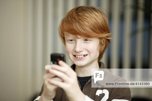 Boy is playing a game on a mobile phone