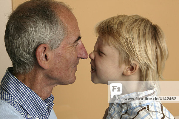 Grandpa and his grandson kiss with their noses