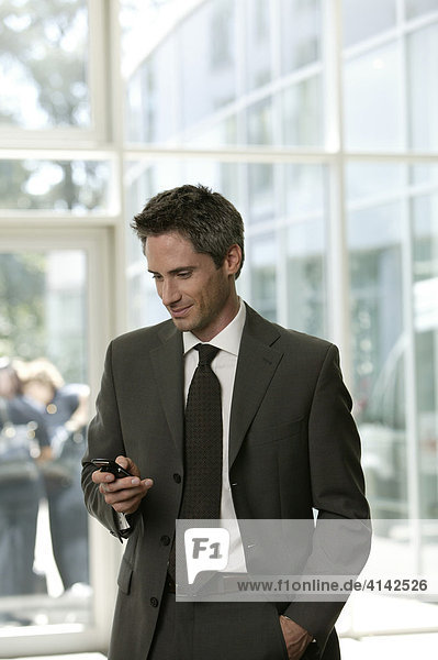 Business man with a mobile phone in the lobby