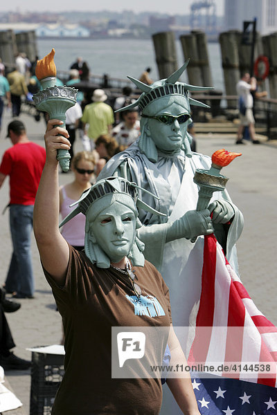 USA  United States of America  New York City: Battery Park  Tourists take pictures with a person dressed like the statue of Liberty.