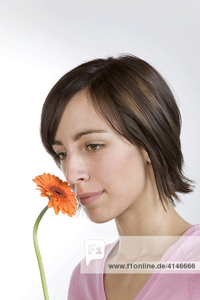Junge Frau riecht an Blume