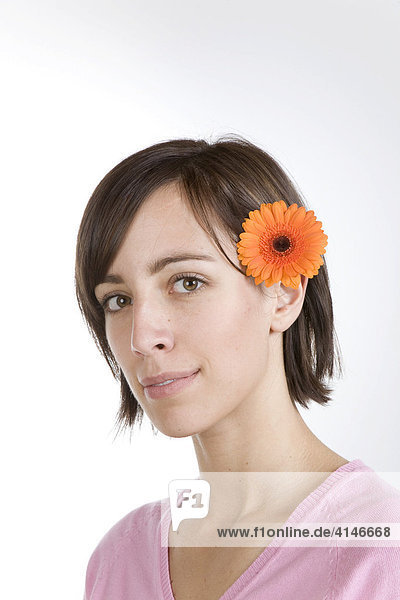 Junge Frau mit Blume hinter dem Ohr