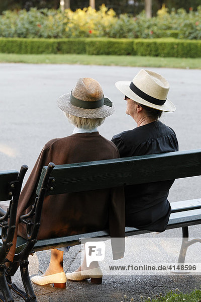 Two female senior citizens sitting on a park bench  Volksgarten  Vienna  Austria