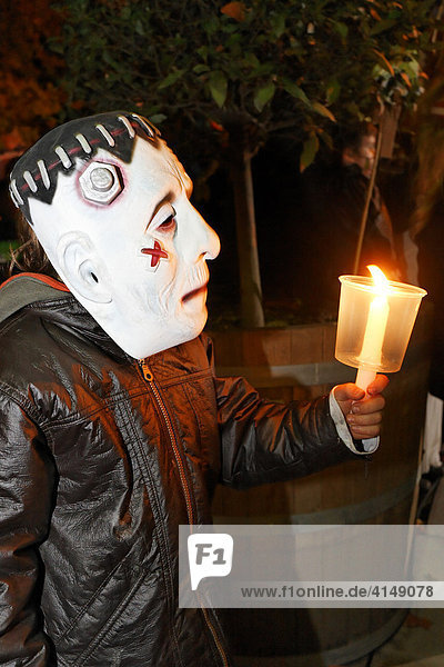 Litlle boy with Frankenstein mask holding a candle Halloween event for children theatre museum Duesseldorf NRW Germany