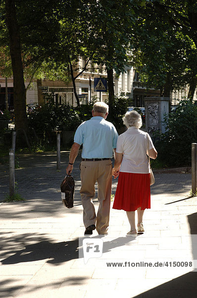 Seniorenpaar geht Hand in Hand